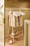 Portant en bois avec des turbulettes beige à motif d'arbres et d'animaux. Une peluche étoile y est accrochée.