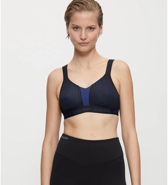 Zwarte sportbeha met een blauw paneel en een gestippelde print, gedragen door een model.