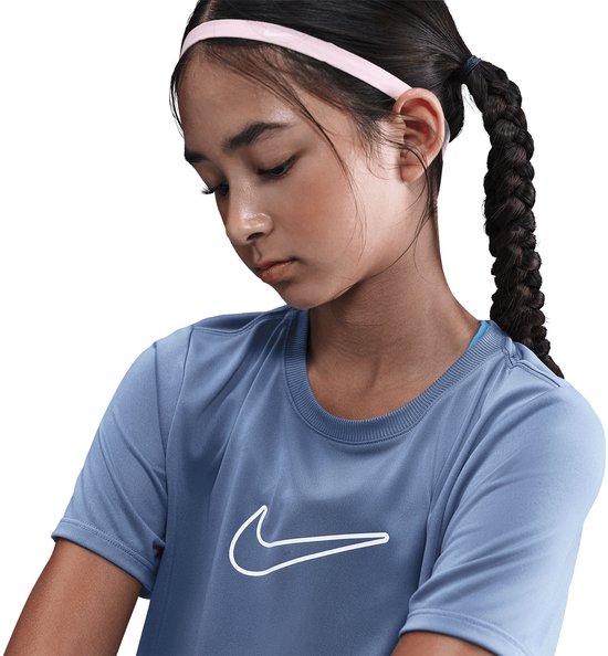 Gedetailleerde foto van een meisje met gevlochten haar, draagt een blauw Nike t-shirt met witte swoosh.