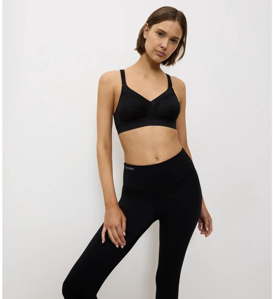 Zwarte Triumph sportbeha met verstelbare bandjes en brede band, gedragen door een model.