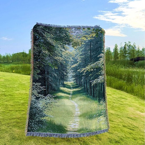 Couverture tissée représentant un chemin forestier verdoyant serpentant entre de grands arbres, avec des franges en haut et en bas.