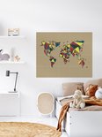 Carte du monde abstraite de style géométrique aux polygones multicolores, accrochée dans une chambre d'enfant au-dessus d'un lit.