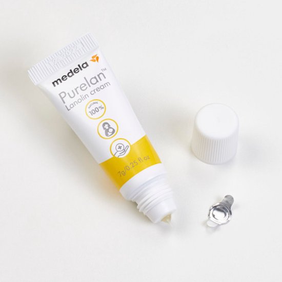 Een open tube Medela Purelan Lanolin cream 7g/0.25 fl.oz met dop en zegel ernaast.