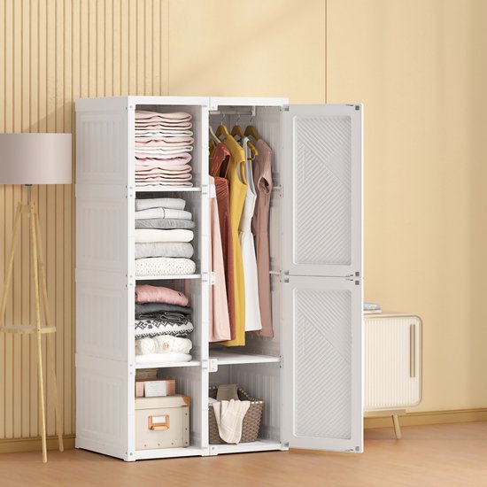 Een open, witte opvouwbare kledingkast, gevuld met gevouwen kleding en kleding aan de kledingroede.