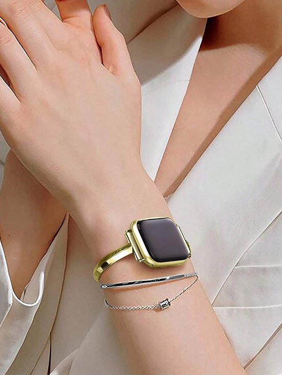 Gouden Apple Watch bandje, open gebogen armbandstijl gedragen om een pols met een dunne zilveren armband.