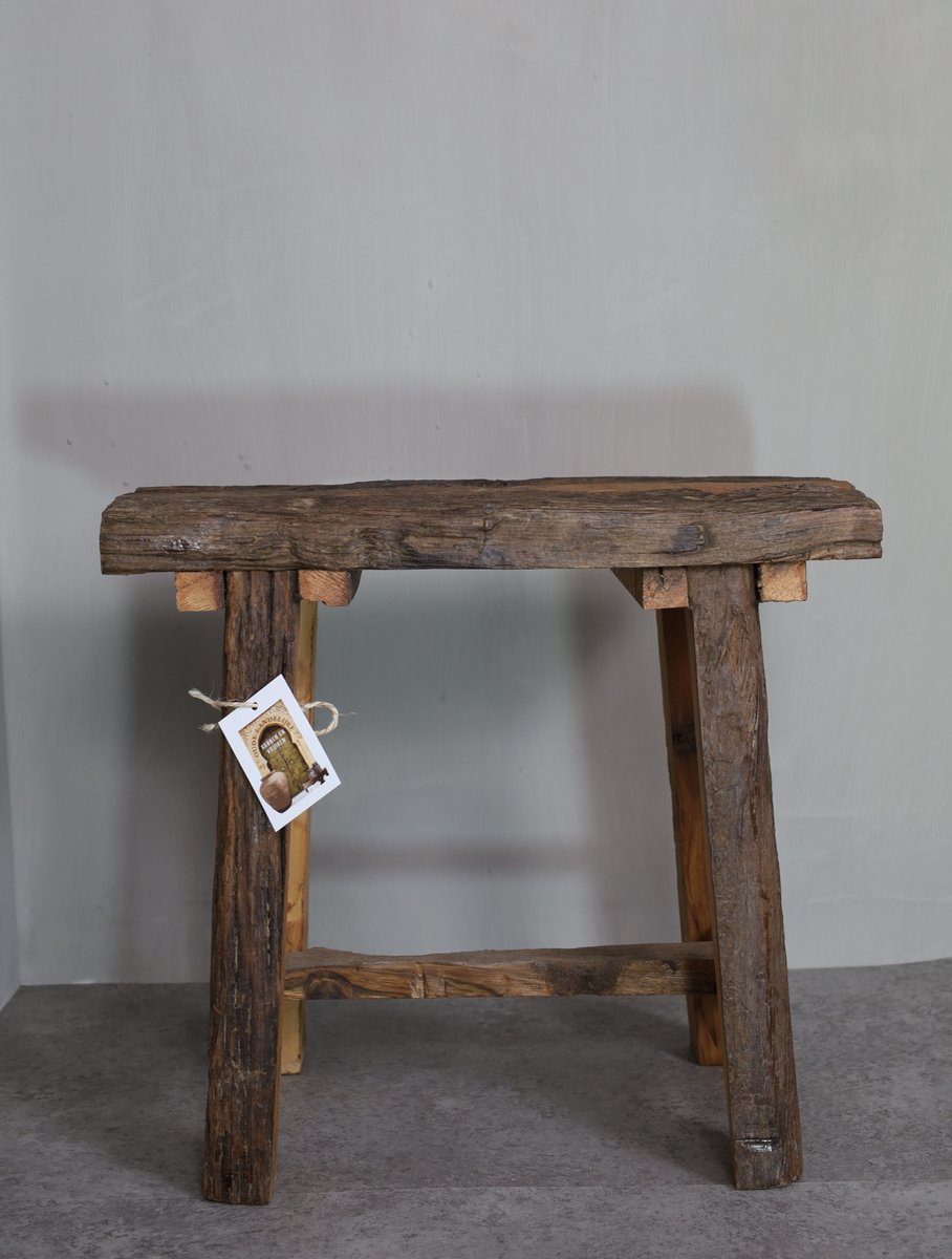 Oud stoer houten krukje donkerbruin oud hout ruw houten krukje