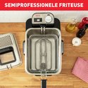 Bovenaanzicht van een RVS frituurpan met mandje en deksel ernaast. De tekst "SEMIPROFESSIONELE FRITEUSE" staat bovenaan in het rood.