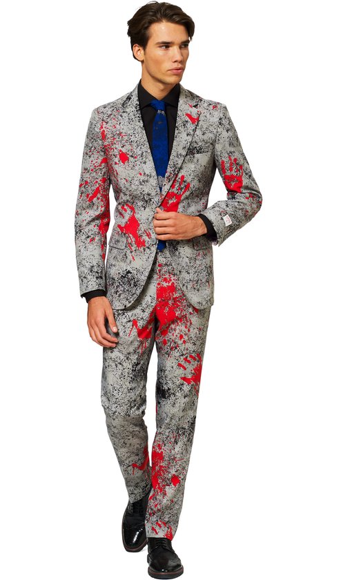 Man in een grijs OppoSuits 'Zombiac' kostuum met rode verfspatten. Het pak bestaat uit een jasje en broek. Hij draagt een zwart overhemd en een blauwe das.