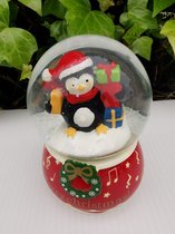 Sneeuwbol met pinguin met kerstmuts en heel veel pakjes
