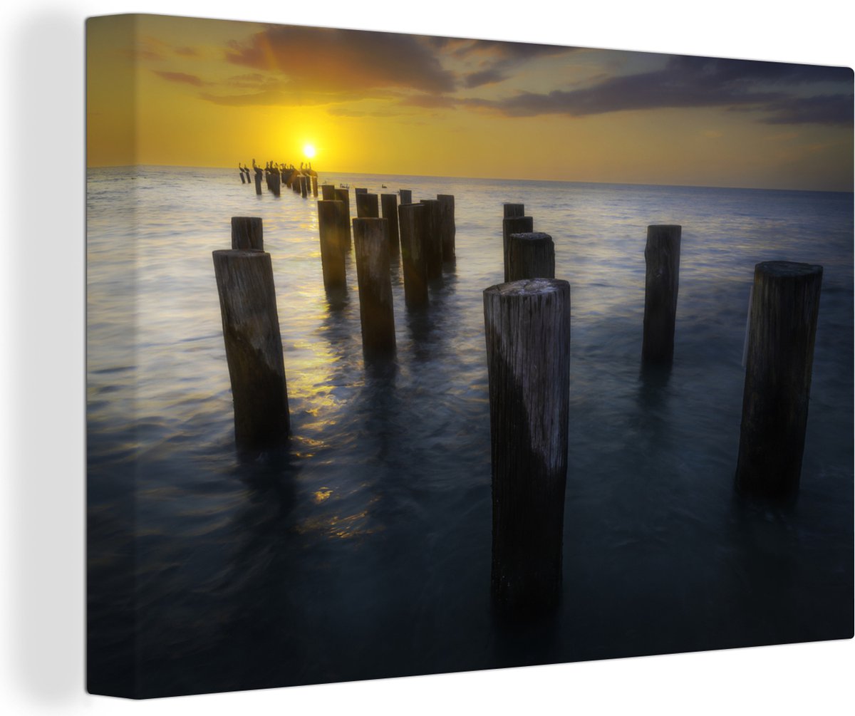 Canvas schilderij 180x120 cm - Wanddecoratie Houten palen in de Golf van Mexico tijdens zo