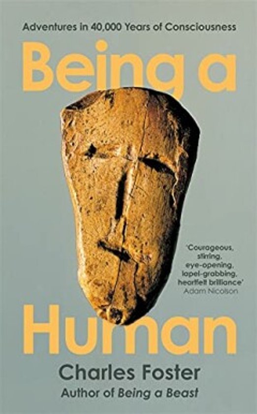 Boek 'Being a Human' van Charles Foster, met een oud stenen masker op de voorkant.