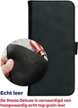 Close-up van zwart echt leer, textuur zichtbaar, naast een lederen telefoonhoes met een tool.