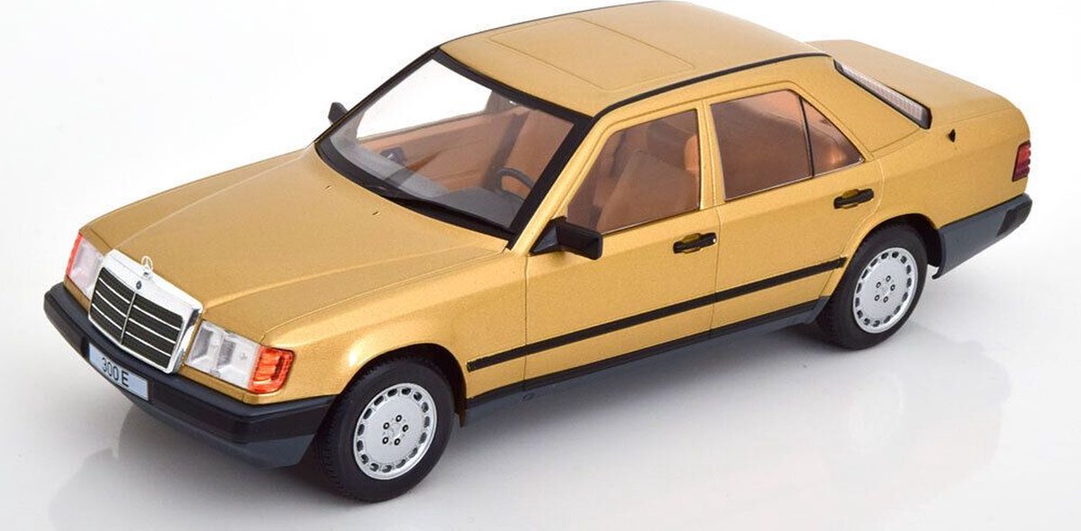 Het 1:18 Diecast-model van de Mercedes-Benz E-Klasse 300E uit 1984 in goud metallic. De fabrikant van het schaalmodel is MCG. Dit model is alleen online beschikbaar