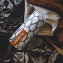 RVS drinkfles met een grijs druppelpatroon en oranje FLASKE-logo, in een bruine tas.