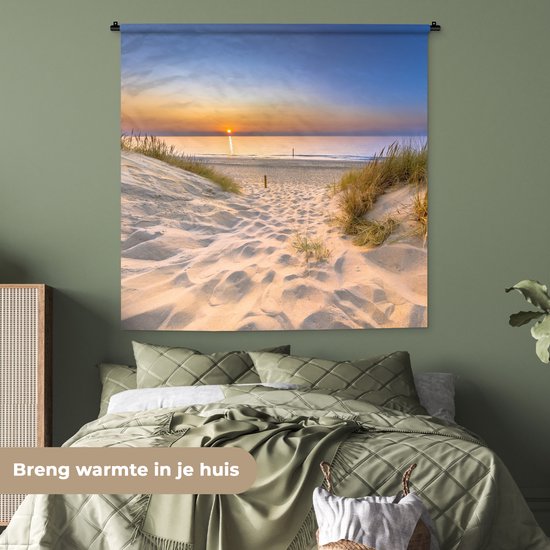 Wandkleed met zonsondergang bij een duinpad, hangend boven een bed in een kamer met groene muren.