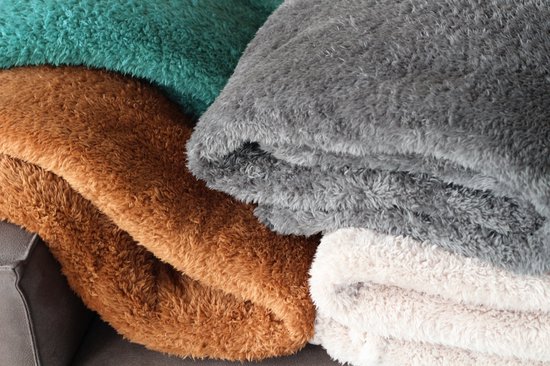 Stapel van zachte plaids in bruin, grijs, crème en teal.