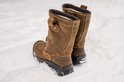 Paar bruine leren werklaarzen in de sneeuw, met Sixton logo en dikke zool.