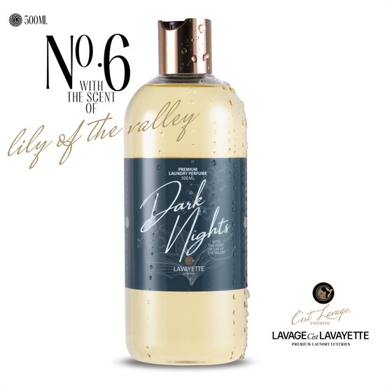 Parfum de linge jaune pâle dans une bouteille transparente avec bouchon doré, avec des gouttelettes d'eau. Texte 'No.6 with the scent of lily of the valley'.