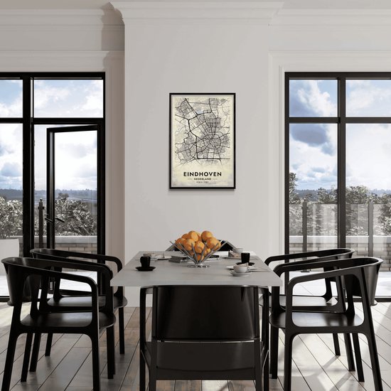 Affiche avec carte d'Eindhoven, Pays-Bas, accroché à un mur blanc au-dessus d'une table à manger.