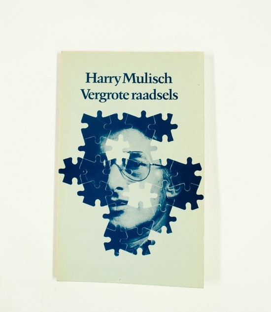 Boek "Vergrote raadsels" van Harry Mulisch met een puzzelafbeelding van een gezicht.