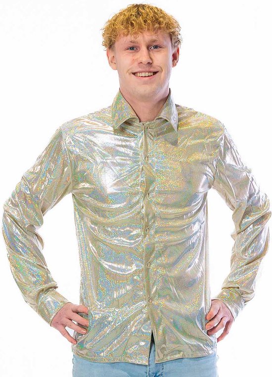 Gros plan d'un homme aux cheveux blonds bouclés portant une chemise à paillettes scintillante or/argent, mains sur les hanches.