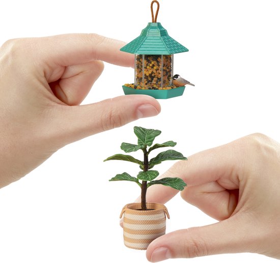 Groene vogelvoeder met koolmeesje en kleine plant in gestreepte pot.
