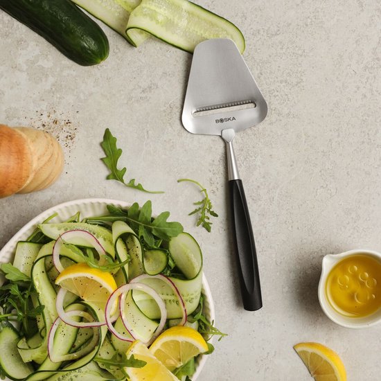 Boska kaasschaaf naast een salade van komkommer, sla en citroen.