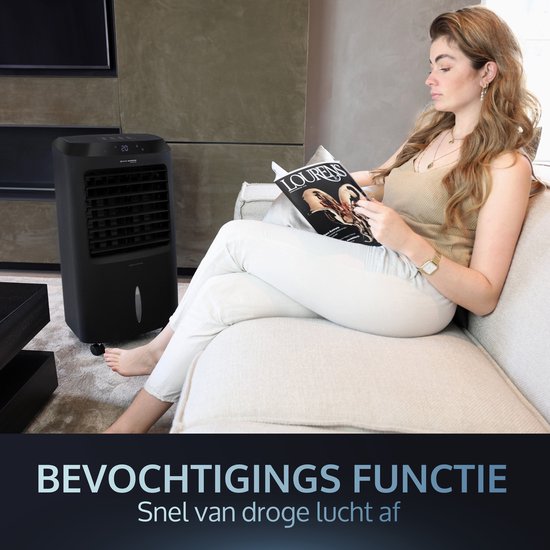 Zwarte mobiele aircooler op de achtergrond terwijl een vrouw op een bank leest, bevochtigingsfunctie.