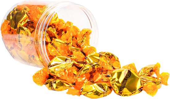 Een doorzichtige bokaal met Trefin Orfina botertoffees die omvallen. De toffees liggen goudkleurig verpakt op de voorgrond.