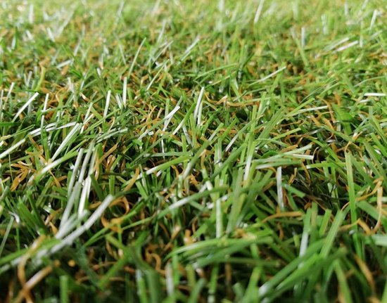 Gros plan détaillé de fibres d'herbe artificielle dans des tons verts et bruns.