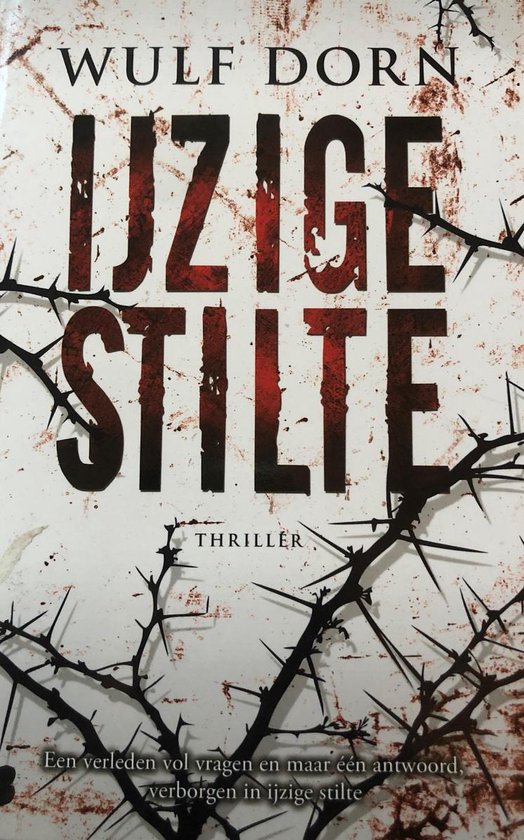 Boek "IJzige Stilte" van Wulf Dorn, thriller. Kaft met doornstruiken, rode letters en tekst: "Een verleden vol vragen en maar één antwoord, verborgen in ijzige stilte".