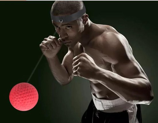 Bokser met hoofdband en rode reflexbal, gefocust op de bal terwijl hij bokst.