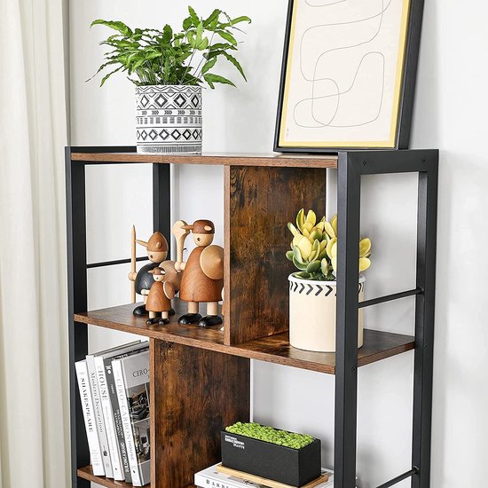 Dichtbij van de bovenste planken van een boekenkast met houten planken en zwarte staanders. Met decoraties, planten en boeken.
