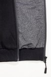 Detail van de opening van een zwarte hoodie met rits en grijsgevoerde capuchon.