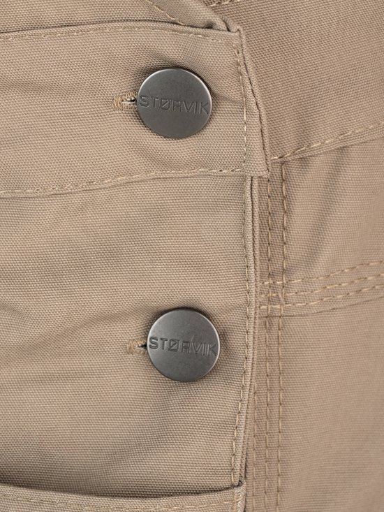 Deux boutons STØRVIK sur une salopette beige.