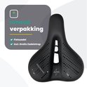 Zwart fietszadel met perforaties en Voltano logo, met de tekst "Inhoud verpakking" en "Fietszadel Incl. GRATIS Zadelstrop".