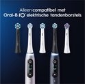 Zwarte en witte elektrische tandenborstels met verschillende opzetborstels erboven, compatibel met Oral-B iO.