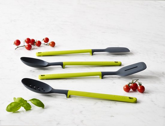Ensemble de quatre ustensiles de cuisine : deux cuillères perforées, une spatule et une cuillère, avec des manches verts et gris foncé, avec des tomates et des herbes.