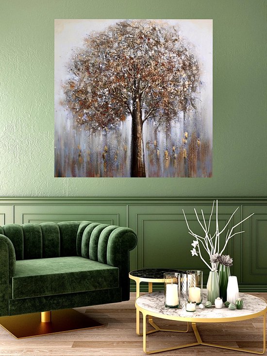 Peinture abstraite d'un arbre brun avec des éclaboussures, accrochée au-dessus d'un canapé vert et de tables en marbre dans un salon.