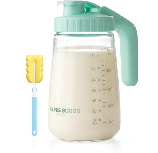 Glazen melkkan met turquoise deksel, gevuld met melk, met een schoonmaakborstel ernaast.