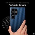 Hand die blauwe, geruite telefoonhoes vasthoudt. Close-up van de geweven textuur.