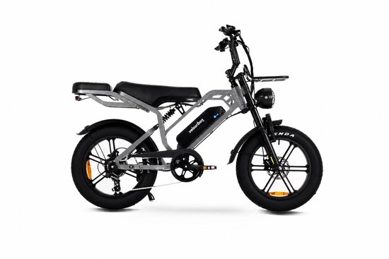 Grijze Velo Urban fatbike met zwarte zitting, voorrek en dikke banden. De 'velourban' tekst is zichtbaar op de accu.