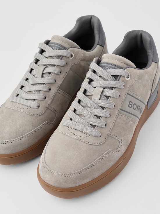 Grijze suède Björn Borg sneakers met bruine zool, details van veters en zijlogo.