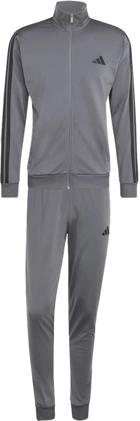 Grijs Adidas trainingspak met zwarte strepen op de mouwen en een Adidas logo op de borst en linker broekspijp.