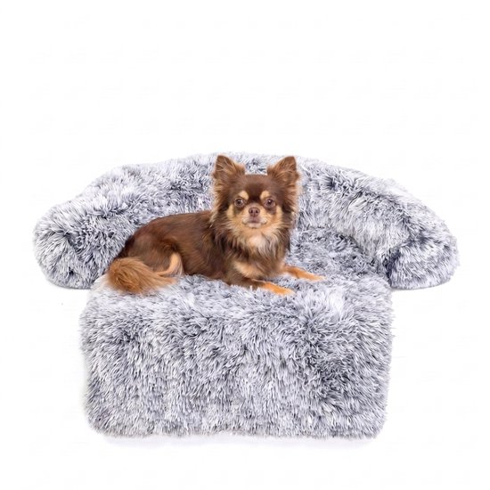 Chihuahua brun allongé sur un canapé pour chien gris ultra doux et duveteux.