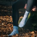 Une personne en automne portant des chaussettes de sport bleu clair.