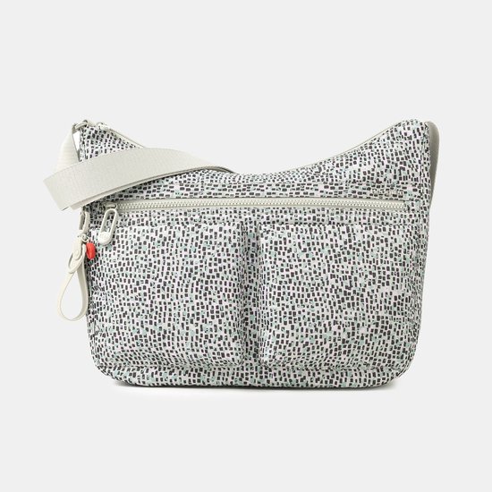 Un sac bandoulière Hedgren à base blanche et imprimé abstrait de carrés noirs, blancs et verts. Le sac possède deux poches avant boutonnées et une bandoulière réglable.