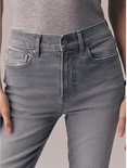 Close-up van de tailleband en zakken van een grijze jeans met een grijze top.