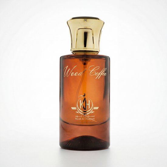 Amberkleurige parfumfles met gouden dop en 'Wood Coffee' opschrift, op een witte achtergrond.