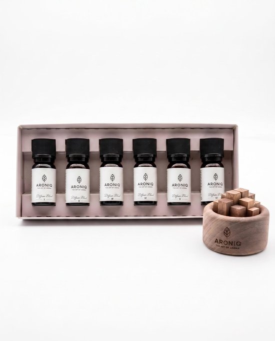 Een set van zes kleine flesjes ARONIQ essentiële olie in een roze doos, naast een houten diffuser met blokjes.